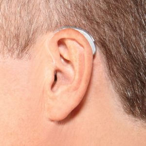 iphone compatible bluetooth hearing aid shown on ear